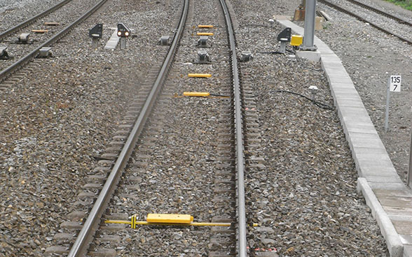 Balises ETCS (jaunes) sur les traverses d’un tronçon ferroviaire.